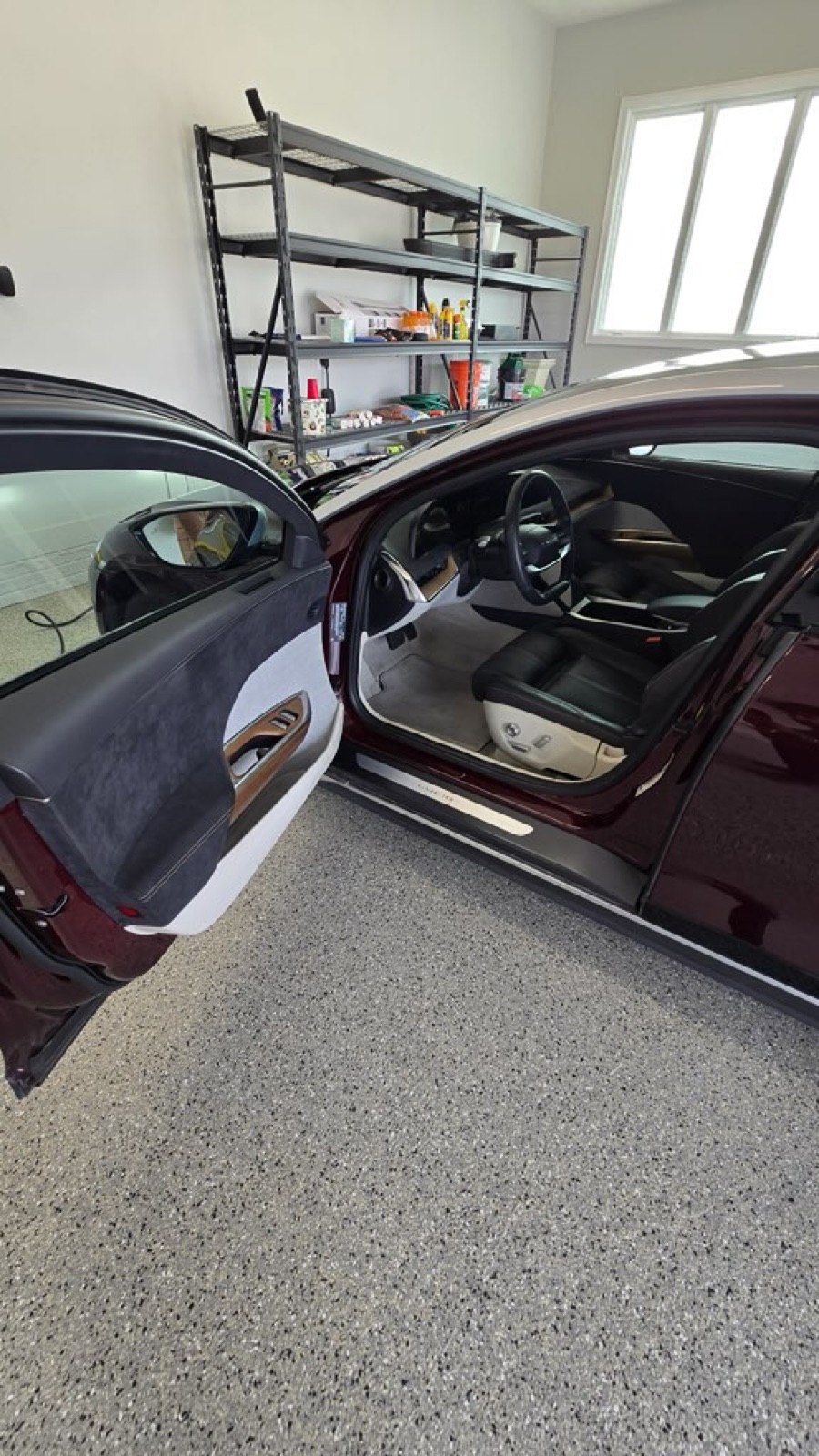 Clean interior through the open door of a detailed sedan